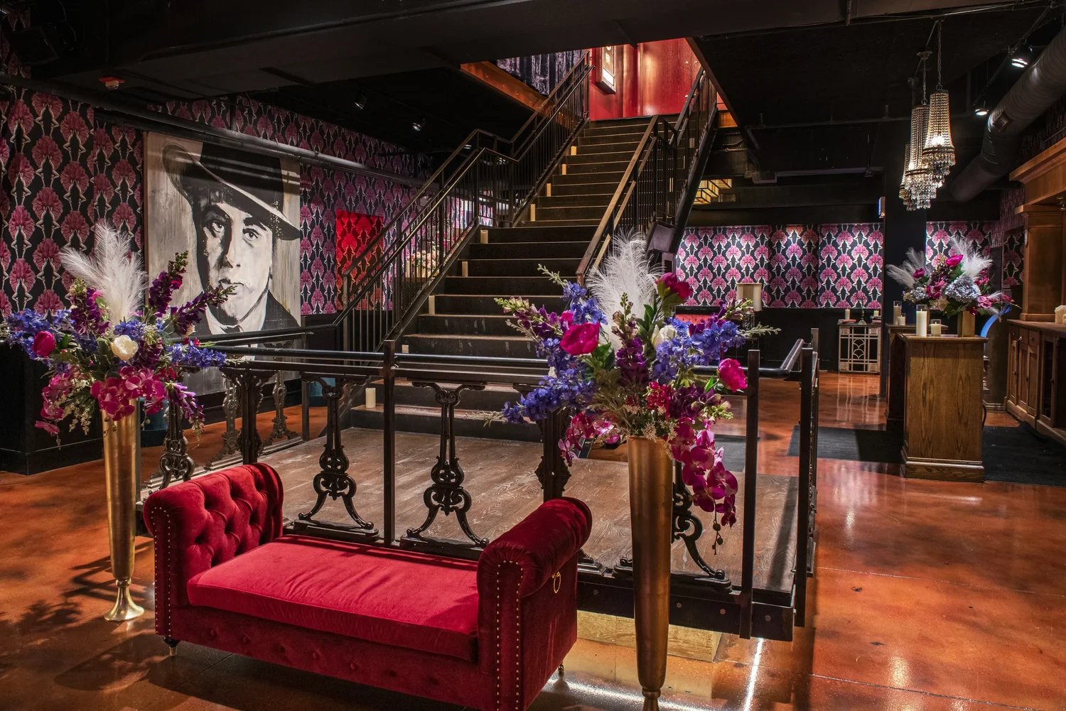 Grand staircase with red velvet seating and floral arrangements